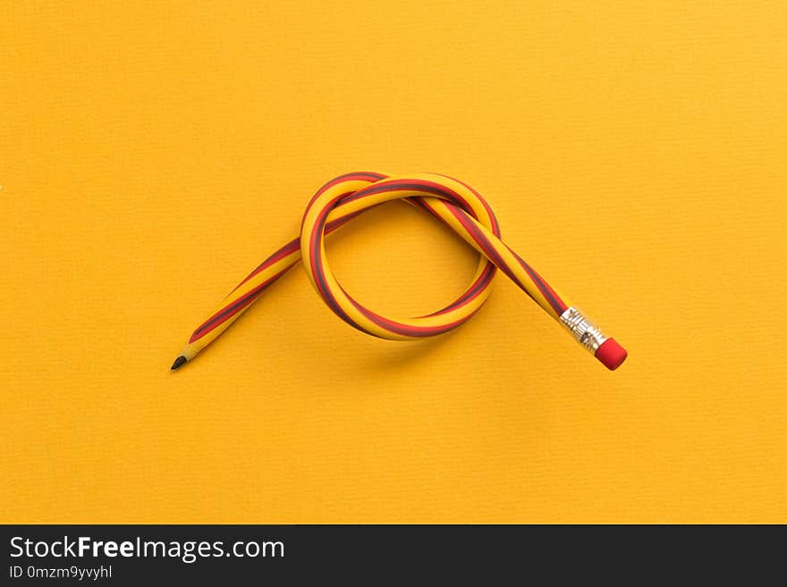 Flexible pencil . Isolated on yellow background.