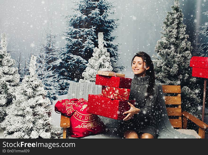 Beautiful woman with pile of Christmas presents.