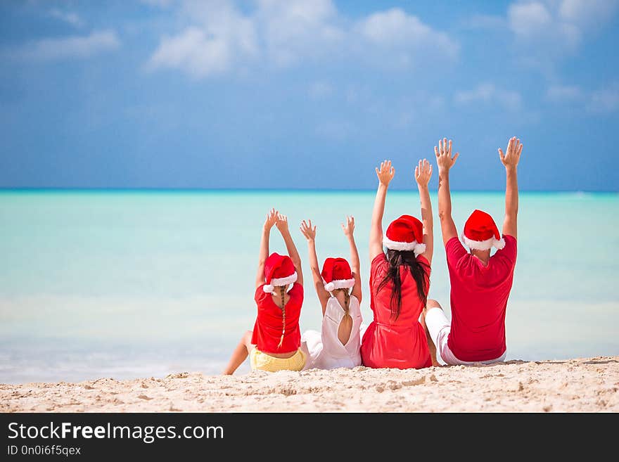 Happy family with two kids in Santa Hat on summer vacation