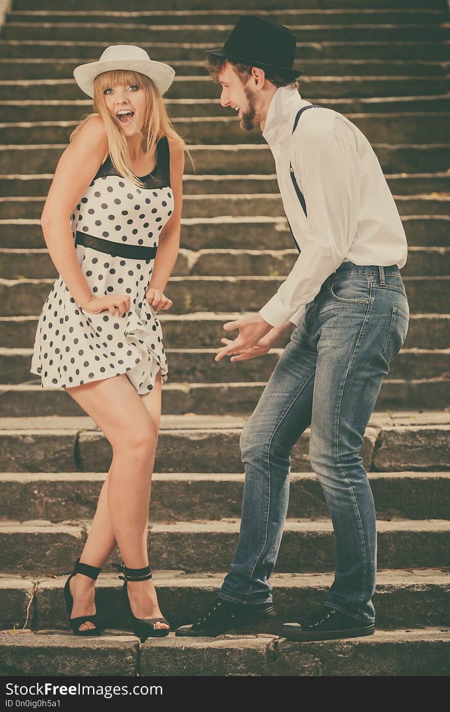 Summer holidays love relationship and dating concept - romantic playful couple retro style flirting on city stairs. Summer holidays love relationship and dating concept - romantic playful couple retro style flirting on city stairs