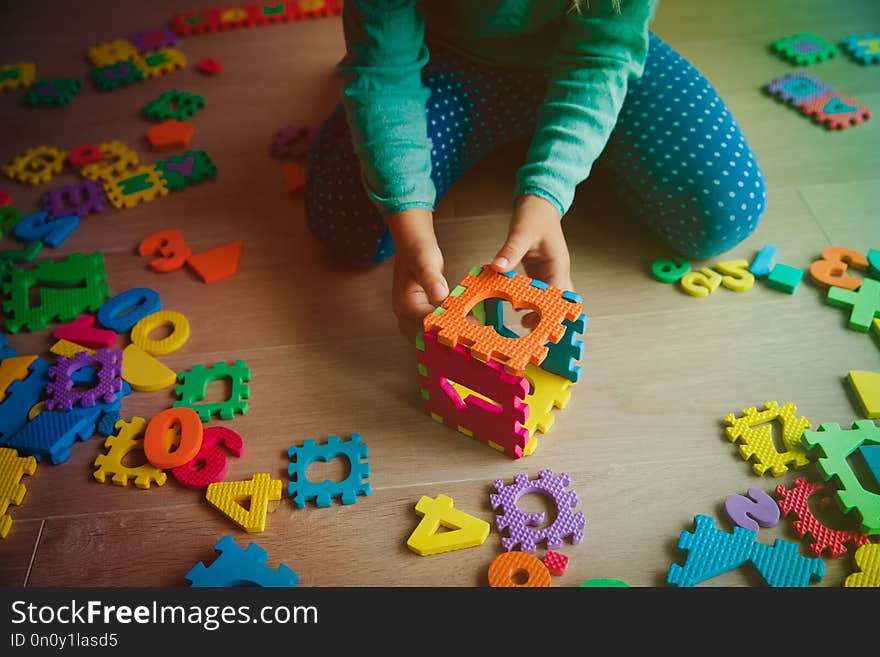 Little girl learning numbers play with puzzle, education