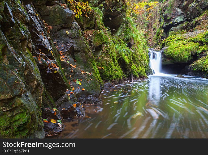 Waterfall in Doubravka valley in autumn, Highlands in Czech Republic. Autumn scenery. Long exposure.