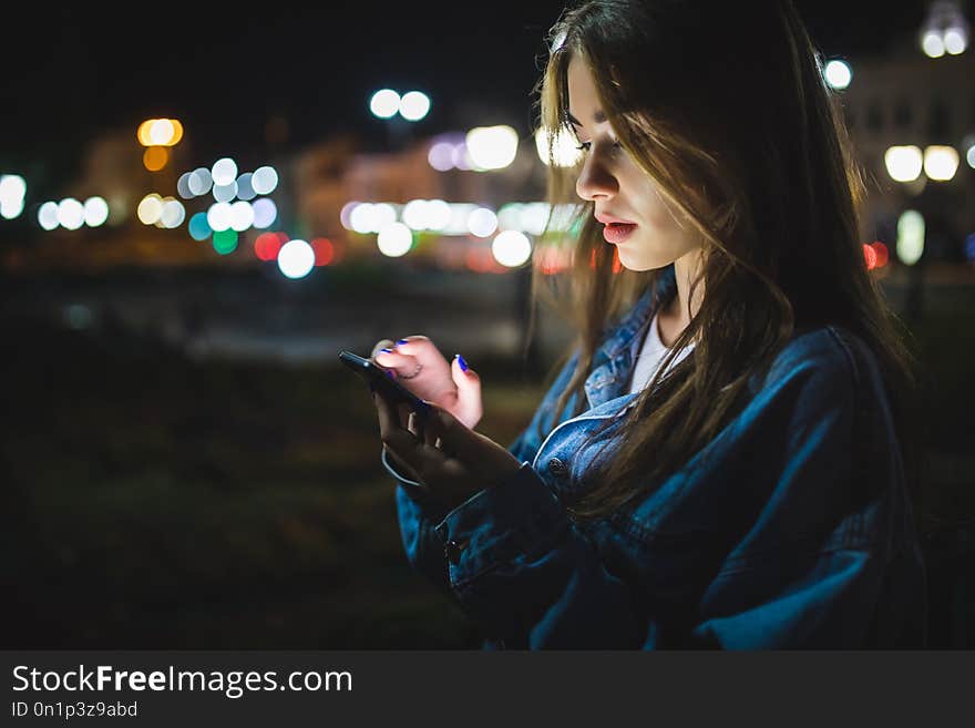 Woman Using Smart Phone Mobile In The City At Night On Light Bokeh