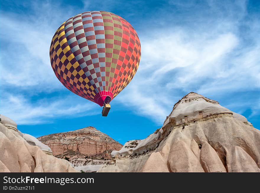 Colorful hot air balloon over mountain landscape against blue sky in Cappadocia, Goreme National Park , Turkey. Colorful hot air balloon over mountain landscape against blue sky in Cappadocia, Goreme National Park , Turkey.