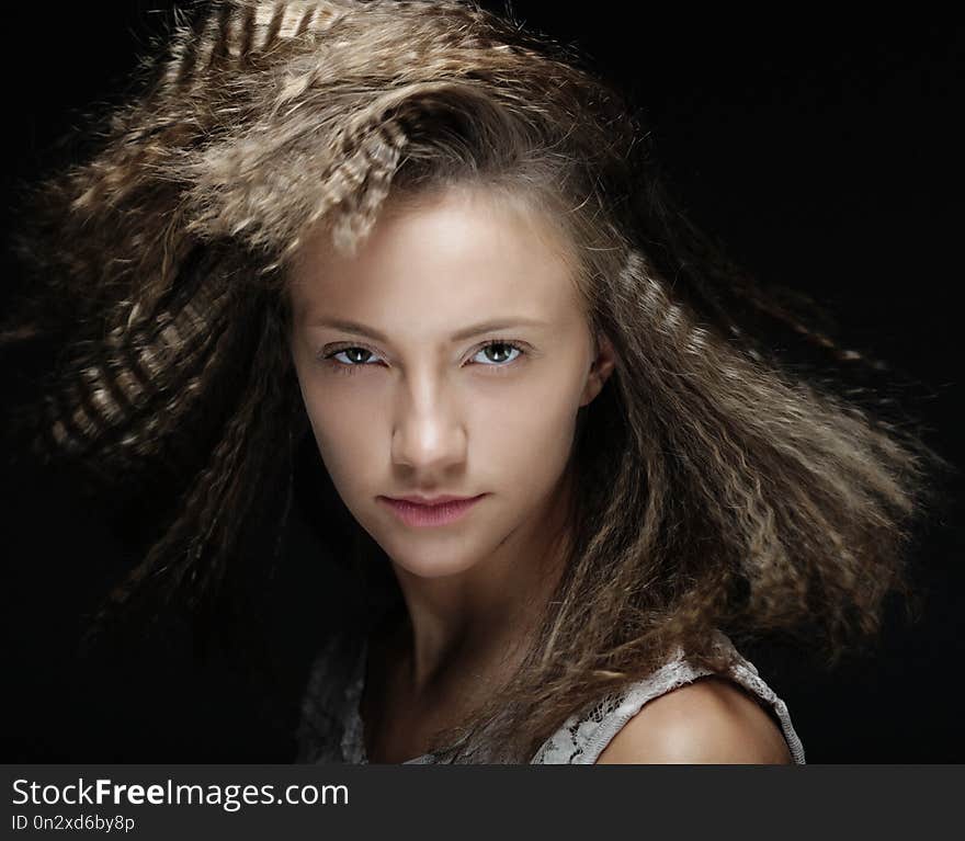 Portrait of young blond woman with curly hair over black background