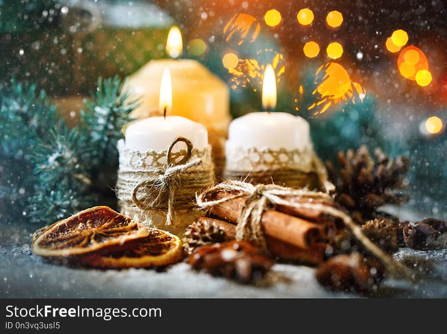 Merry Christmas and happy New year. Candle and Christmas toys on a wooden table. Bokeh. Selective focus.