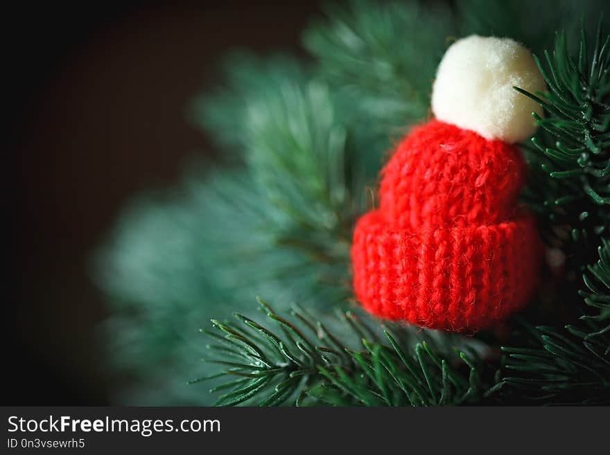 Merry Christmas and happy New year. Little knitted hat on the Christmas tree. Background with copy space.