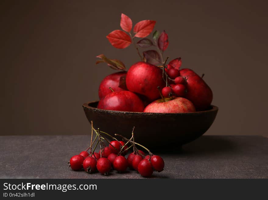 Autumn still life with hawthorn berries and apples in plate.