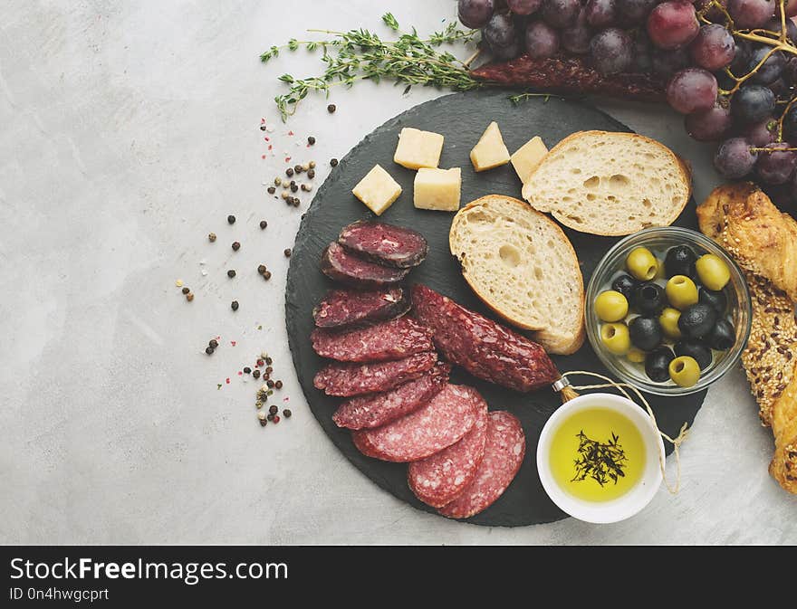 Salami sliced in rustic style. Salami sausage. Different sausages with cheese, grapes and olive. Toned, top view.