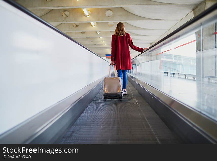 Young woman in international airport with luggage