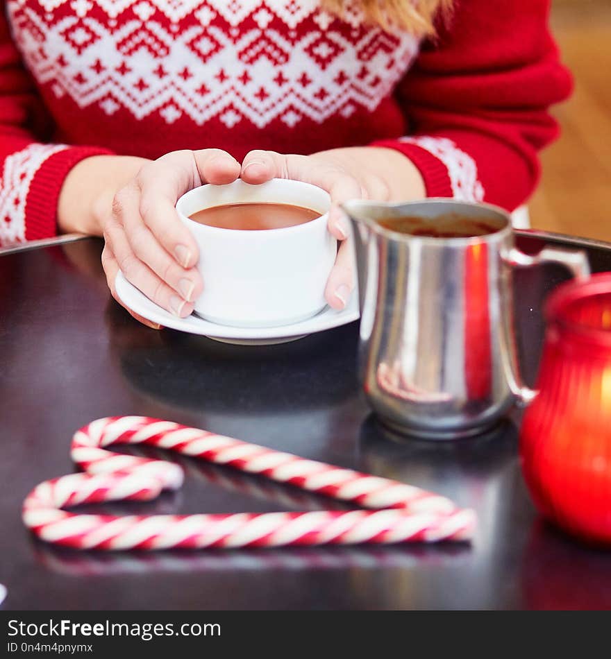 Woman drinking hot chocolate in a cozy outdoor Parisian cafe decorated for Christmas. Woman drinking hot chocolate in a cozy outdoor Parisian cafe decorated for Christmas