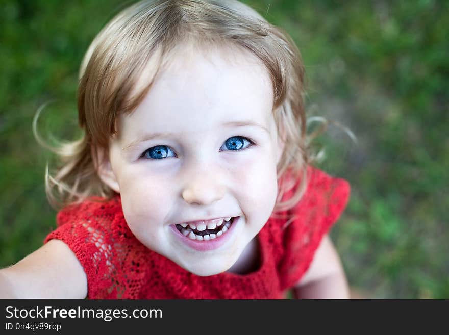 Funny kid girl wide smiling face closeup top view. Funny kid girl wide smiling face closeup top view