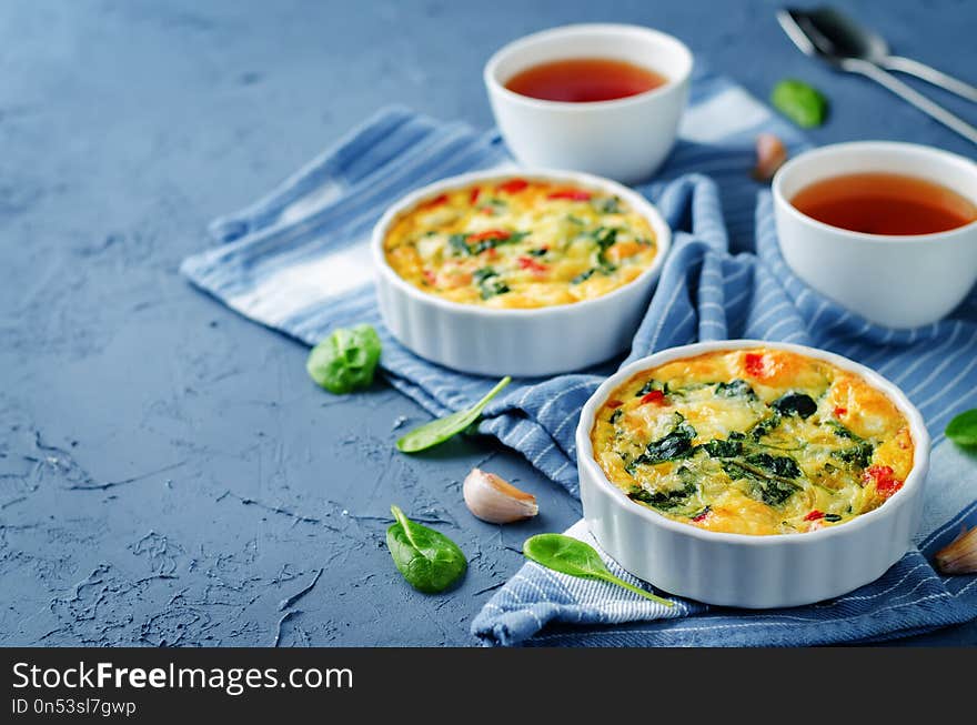 Spinach Red Bell Pepper Baked Omelet with cups of tea and fresh spinach leaves. toning. selective focus