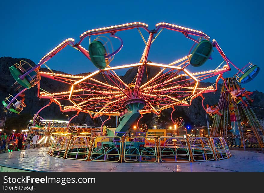 Colorful carousel spinning in the amusement park at night. Colorful carousel spinning in the amusement park at night.