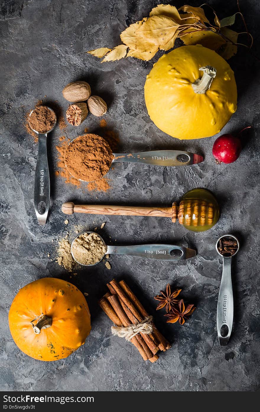 Pumpkin pie spices in measuring cups, rustic background