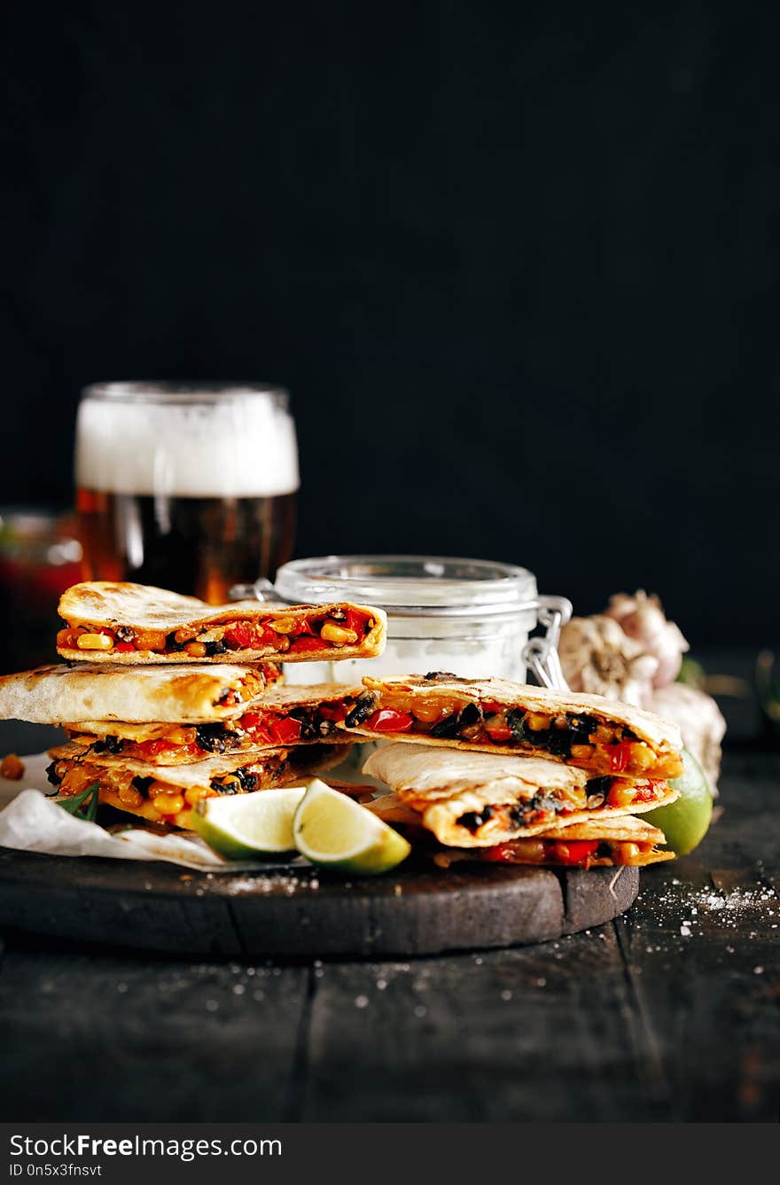 Vegetarian beer snacks: quesadilla with vegetables and cheese on dark background. Vegetarian beer snacks: quesadilla with vegetables and cheese on dark background