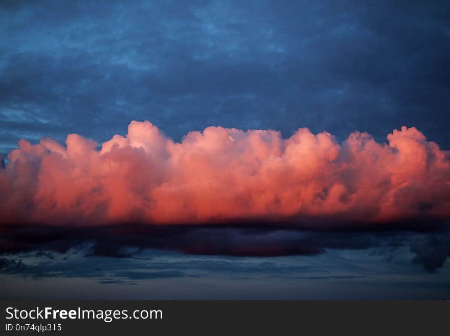 Pink cotton candy cloud fly above city