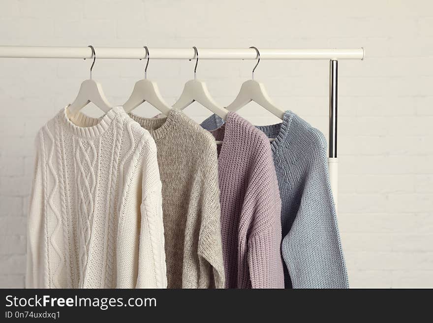 Collection of warm sweaters hanging on rack