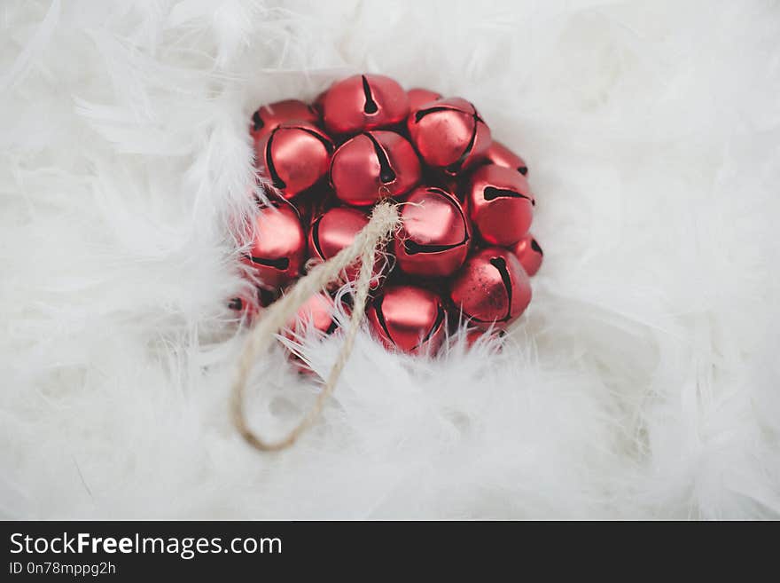 Christmas card. Red Christmas ball on a background of white feathers.