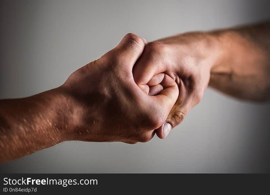 Male hand united in handshake. Man help hands, guardianship, protection. Two hands, arm, helping hand of a friend. Handshake, arms. Friendly handshake, friends greeting. Rescue helping hand