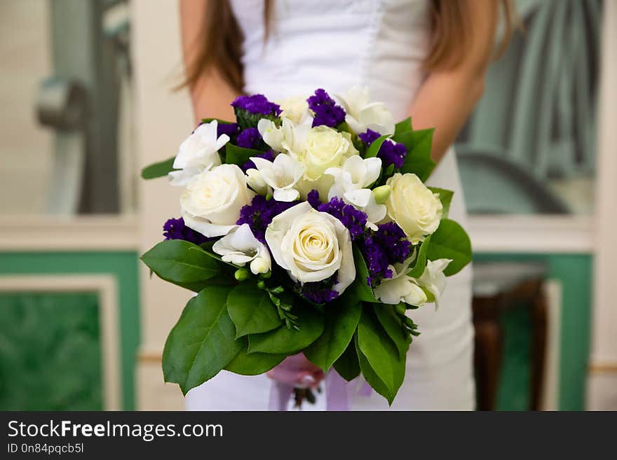 Wedding bouquet of flowers in the hands of the bride. Wedding bouquet of flowers in the hands of the bride