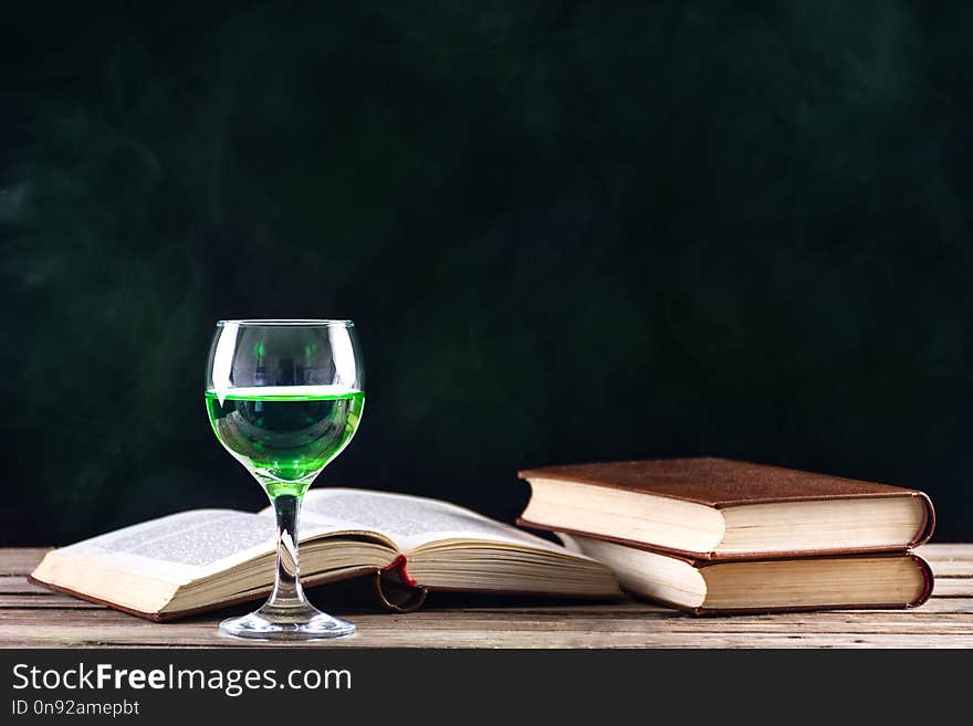 Absinthe Drink In Glass And Books With Candle In Candlestick