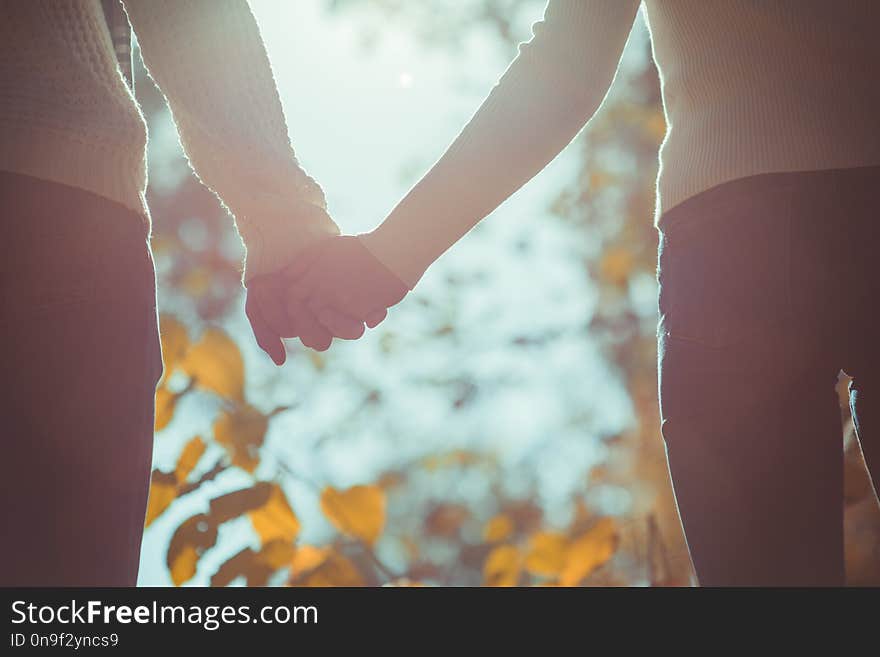 Cute couple in matched clothes is holding hands together and enjoying the view of the nature. Cute couple in matched clothes is holding hands together and enjoying the view of the nature