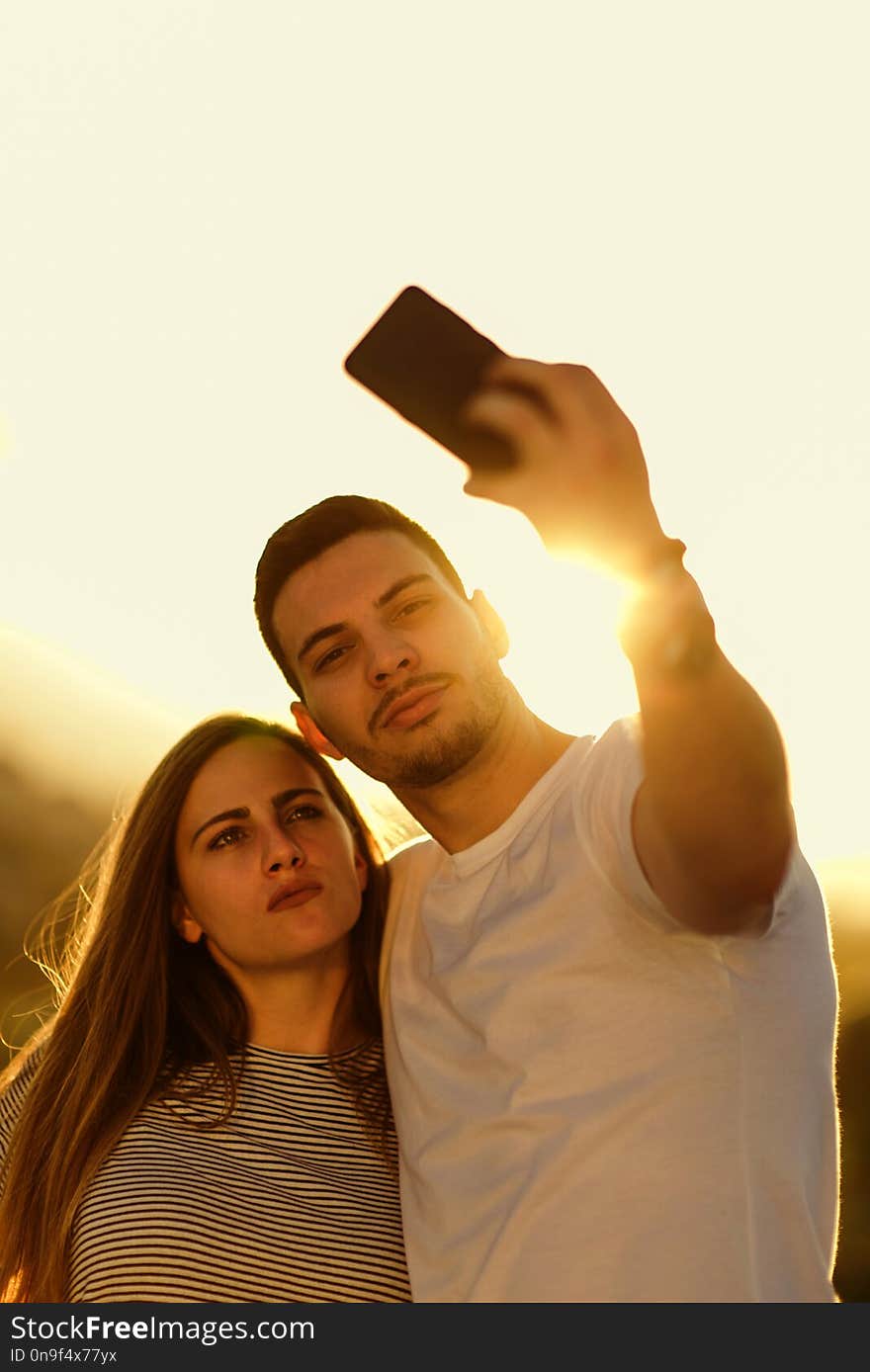 Young Couple Taking Selfie With Smartphone On The Rooftop