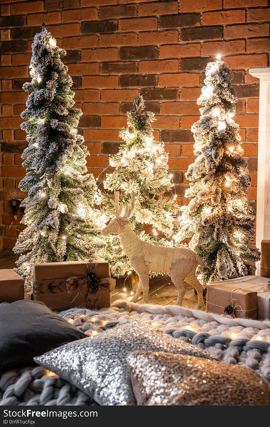 Loft apartments, brick wall with candles and Christmas tree wreath. Bed in the bedroom, high large Windows. Loft apartments, brick wall with candles and Christmas tree wreath. Bed in the bedroom, high large Windows.