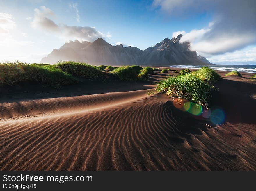 Fantastic west of the mountains and volcanic lava sand dunes on the beach Stokksness, Iceland. Colorful summer morning Iceland, Europe.