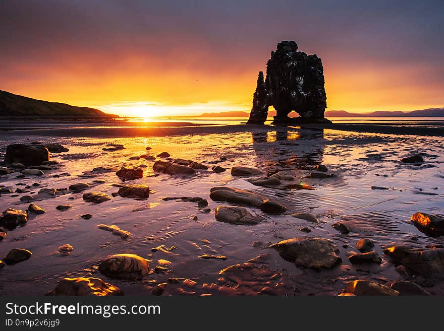 Is a spectacular rock in the sea on the Northern coast of Iceland. Legends say it is a petrified troll. On this photo Hvitserkur reflects in the sea water after the midnight sunset.