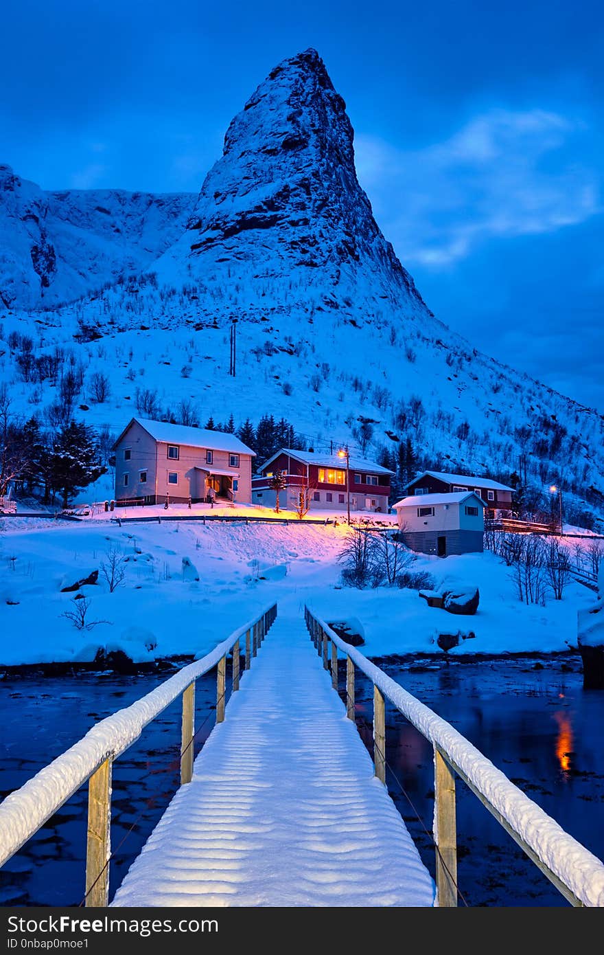 Bridge in Reine village covered with snow at night. Lofoten islands, Norway. Bridge in Reine village covered with snow at night. Lofoten islands, Norway