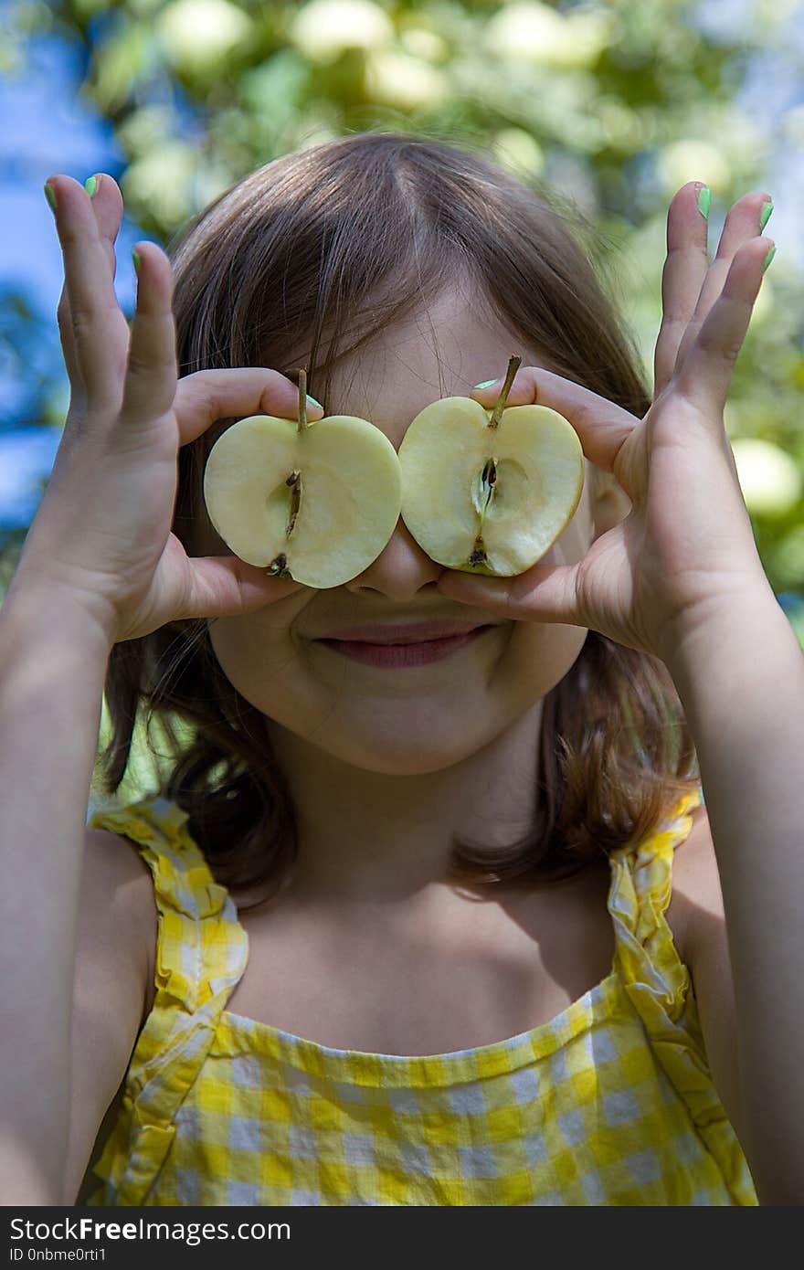 Nice girl with half apples. On natural background