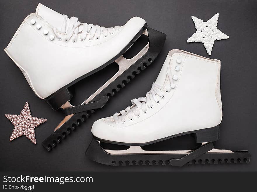 Skates and shiny stars on black background.