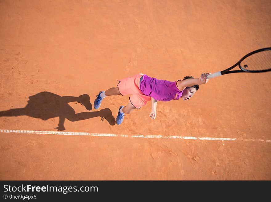 Young tennis player serving the ball with high impact