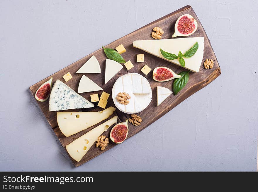 Cheeseboard with cheese brie , parmesan , camembert and dorblu . Food on wooden board