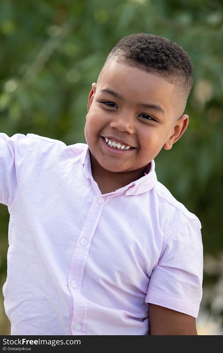 Adorable latin child in the garden with a beautiful green of background