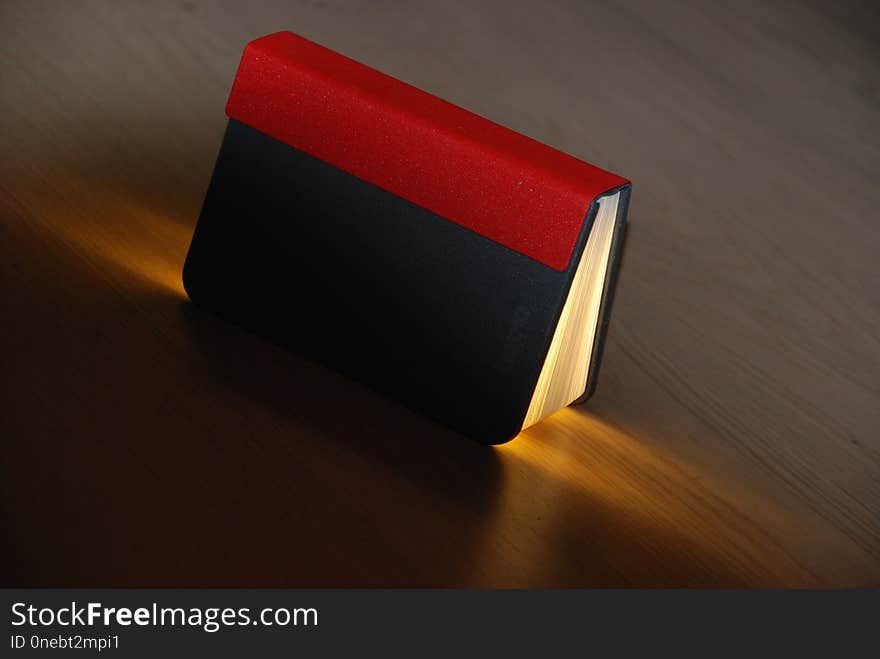 Book-shaped lamp on the wooden floor.