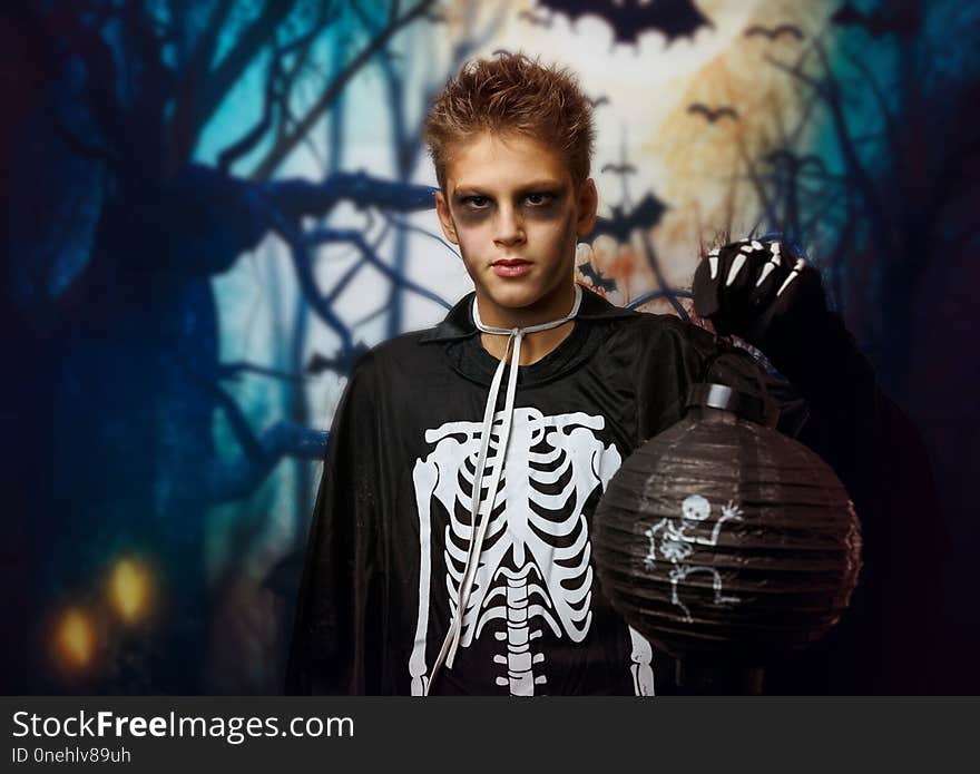 Portrait of young boy in skeleton costume with makeup. Celebration of holiday Halloween, the boy in the image, the skeleton theme,the vampire,bat.