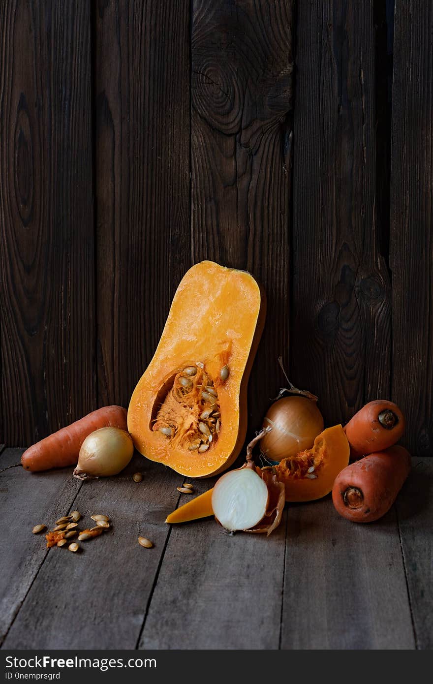 Pumpkin, onion and carrot on a wooden background, vegetables for