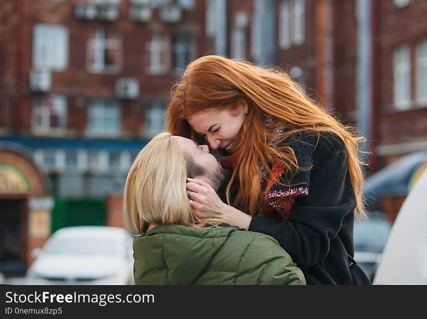 Winter holiday, dating, urban fashion and relationship concept. Stylish cheerful couple embracing in the winter street.