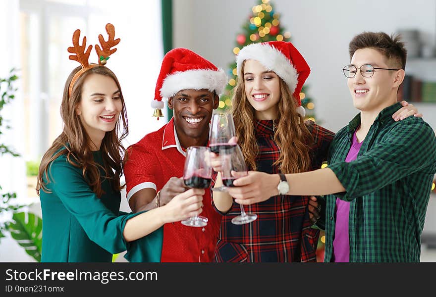 Company of cheerful and happy friends celebrating at the christmas dinner