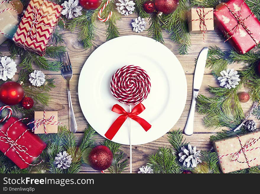 Festive table setting with cutlery, fir branches and Christmas decorations on wooden table. Top view. Christmas tableware