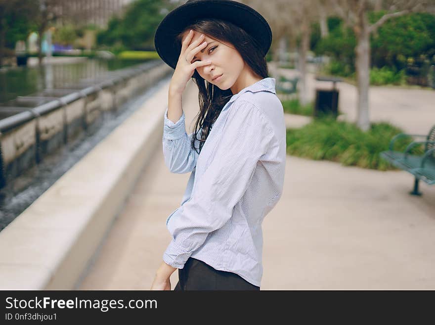 Young model brunette on the street in a hat