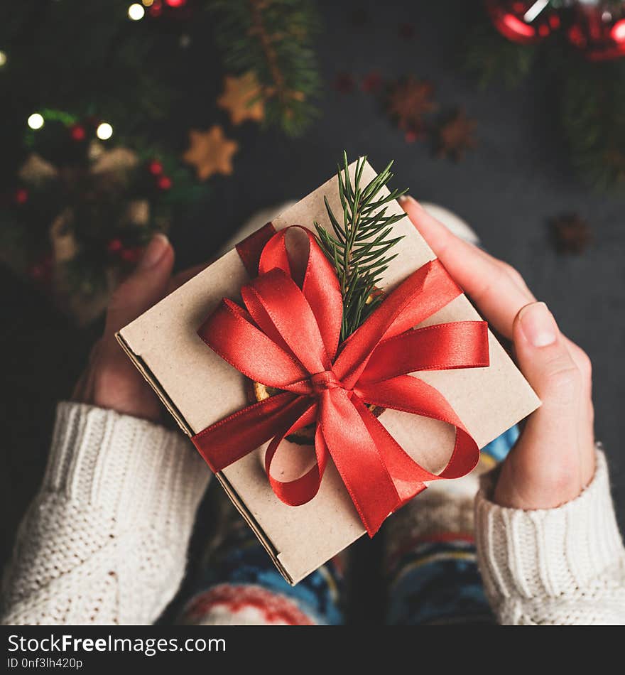 Christmas Gift Box With Red Lace In Hands. Craft Paper Gift Box Package. Hands Holding Christmas or New Year Present