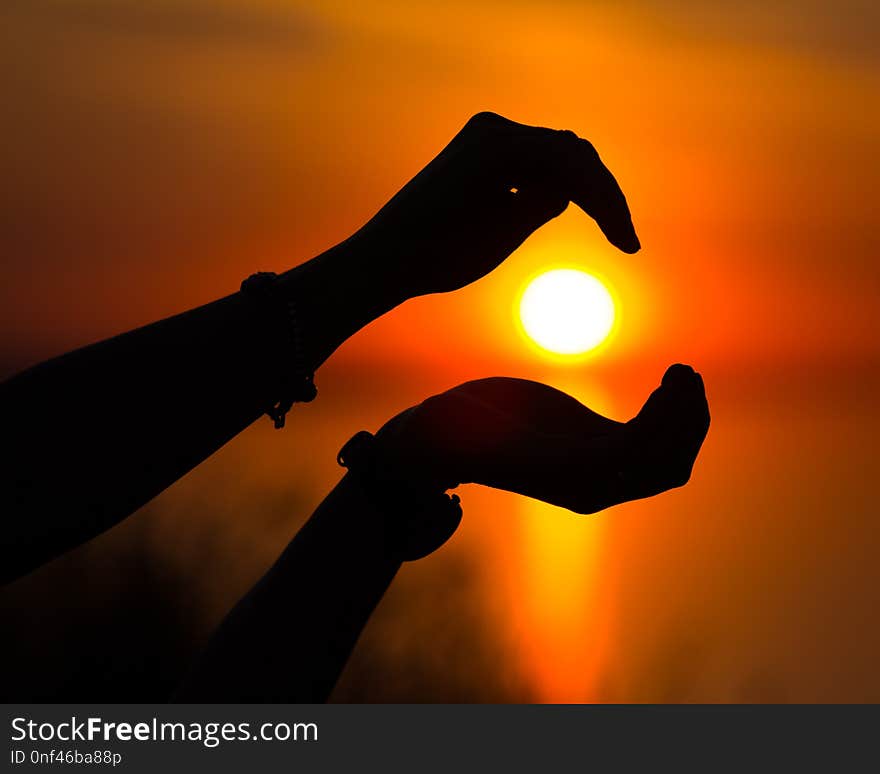 Sun silhouette at sunset centered on two hand bringing peace to the viewer. Sun silhouette at sunset centered on two hand bringing peace to the viewer