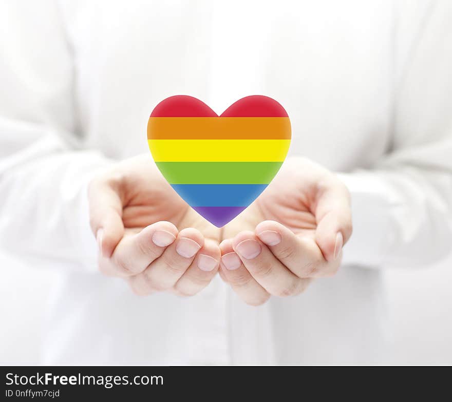 LGBT rainbow heart symbol of love in man& x27;s hands. LGBT rainbow heart symbol of love in man& x27;s hands