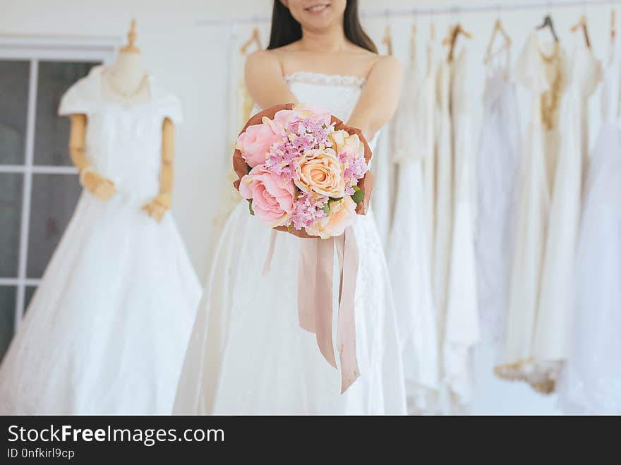 Bride holding a bouquet on hand for wedding,Beautiful asian woman smiling and happy,Romantic and sweet moment