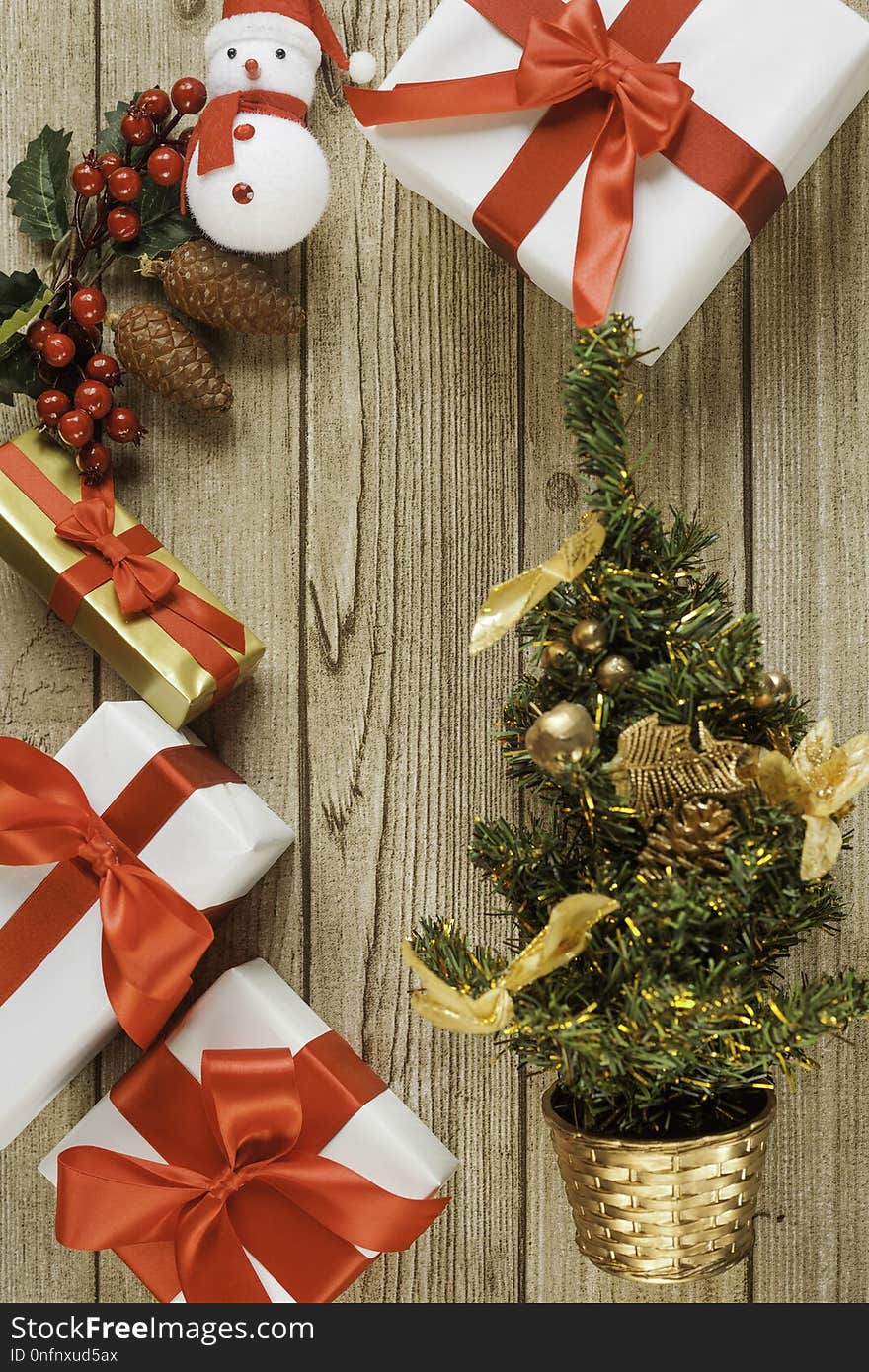 Santa, christmas presents, christmas tree and mistletoe with pine cones on wood table from above. Santa, christmas presents, christmas tree and mistletoe with pine cones on wood table from above