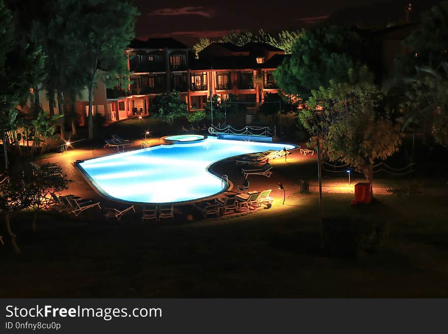 View from the window in the evening on the courtyard of the hotel with a swimming pool and a small residential building. View from the window in the evening on the courtyard of the hotel with a swimming pool and a small residential building